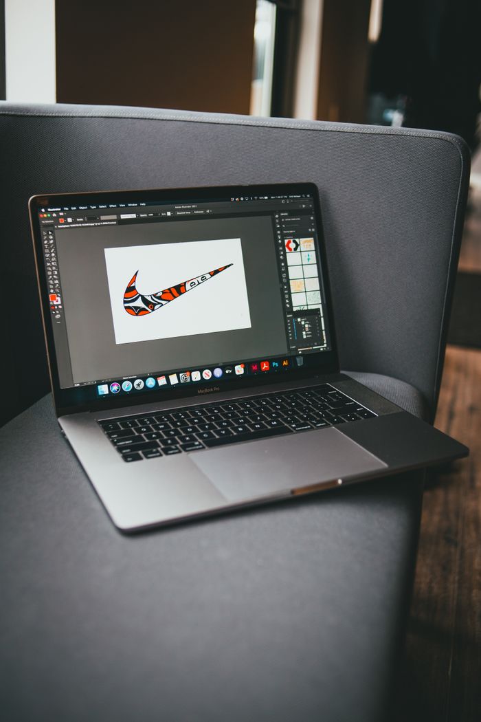 Vue prise du dessus d’un netbook moderne avec un logiciel graphique ouvert, posé sur un canapé gris dans une pièce